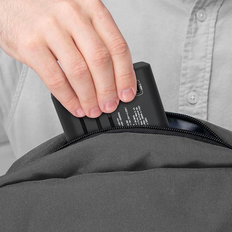 O Adaptador Universal de tomadas VX sendo guardado dentro da bolsa para viagem