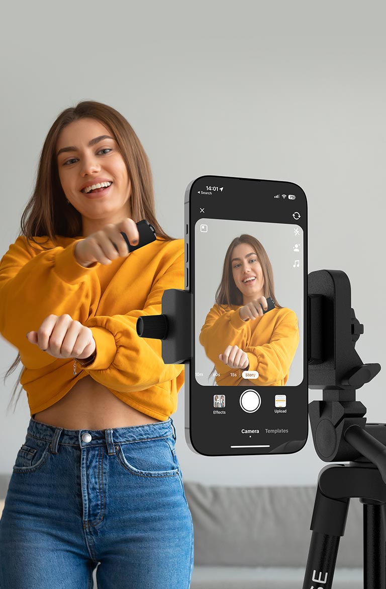 Garota tirando fotos com o controle bluetooth do Tripé Fotográfico VX Case conectado ao smartphone